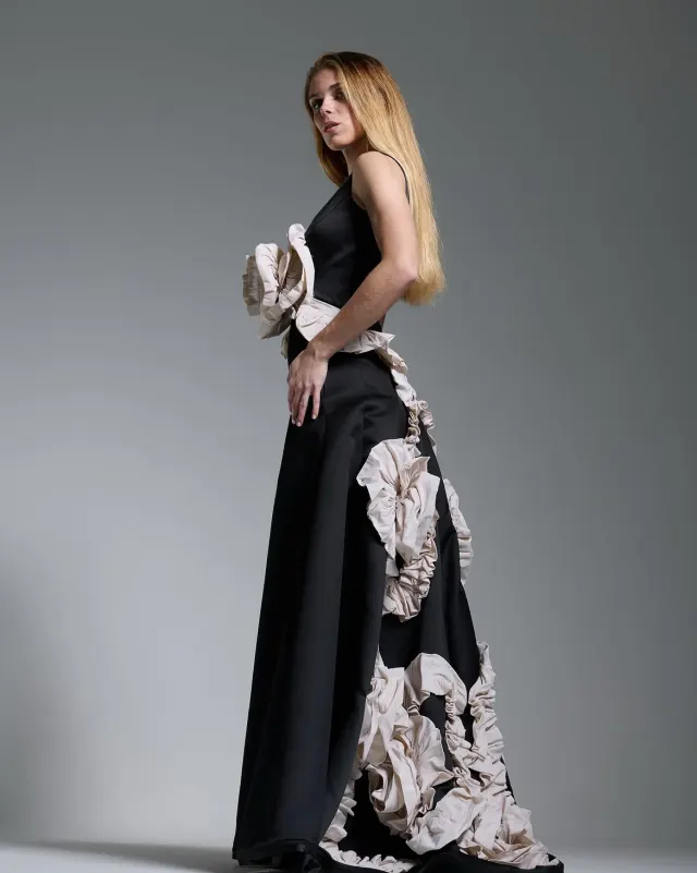 Vestido de gala negro en movimiento, falda con vuelo y rosas en crudo