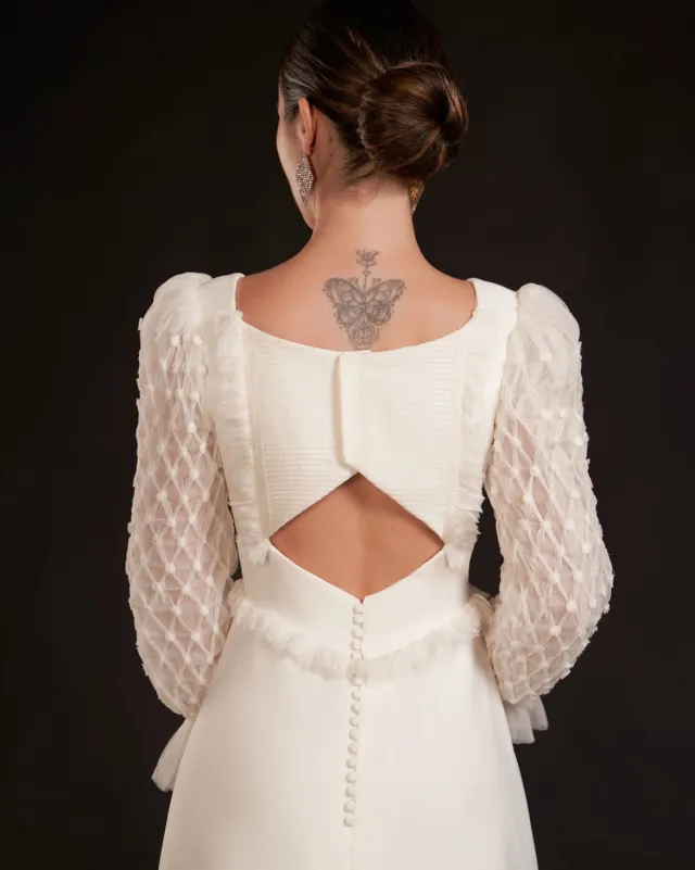 Espalda de vestido de novia con tul de rejilla, plumeti y botones forrados