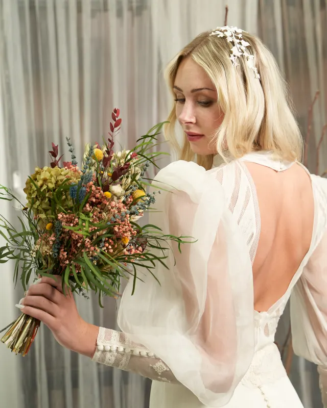 Novia con vestido a medida de mangas globo de organza y ramo silvestre
