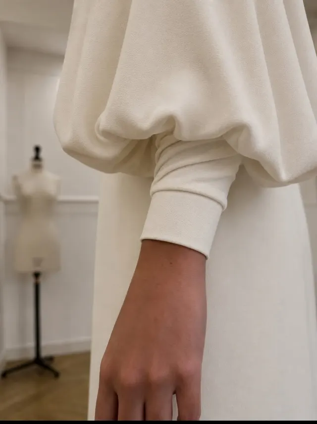 Vestido de novia a contraluz junto a la ventana del atelier